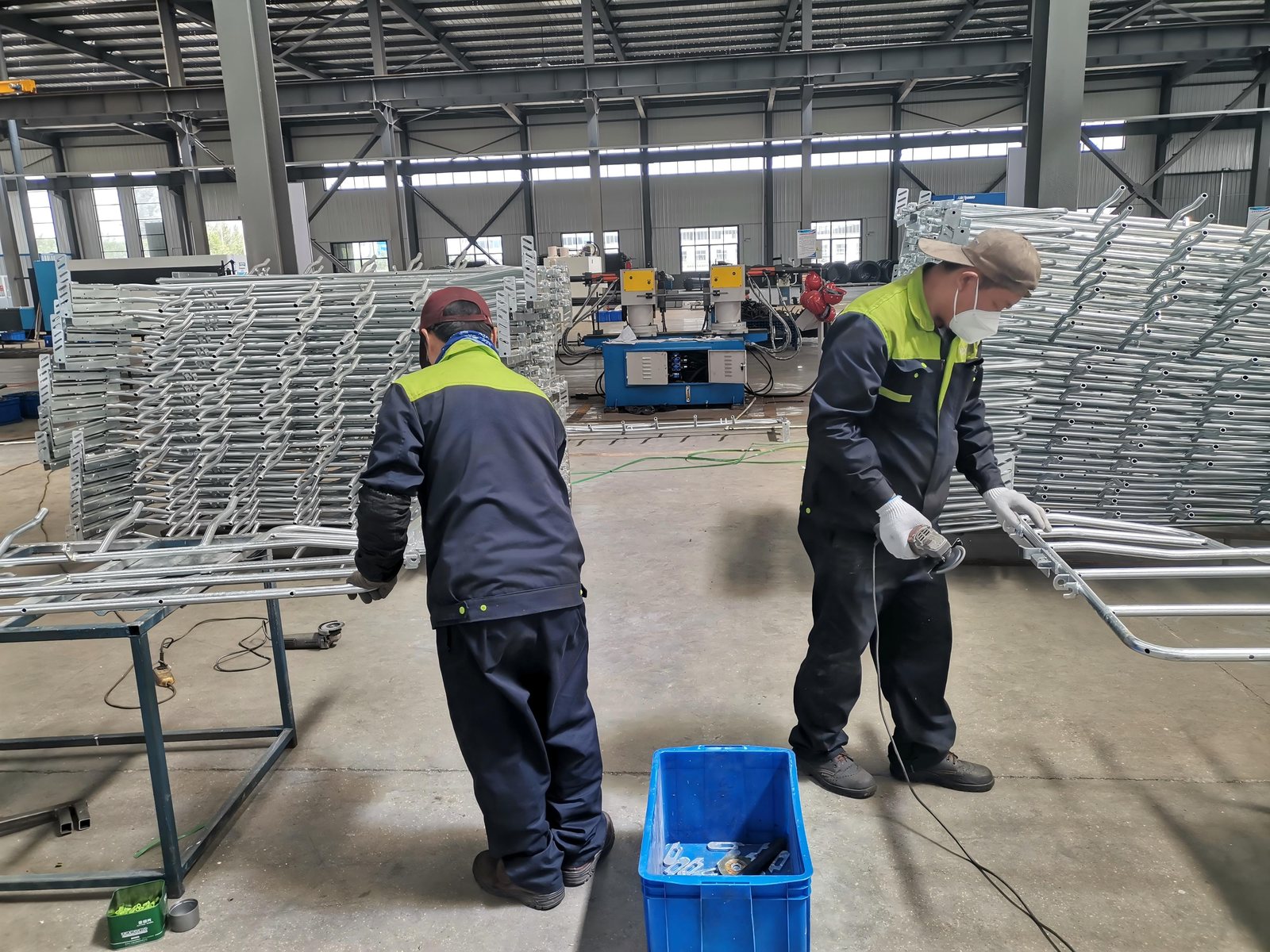 Workers preparing pig farm equipment in a workshop